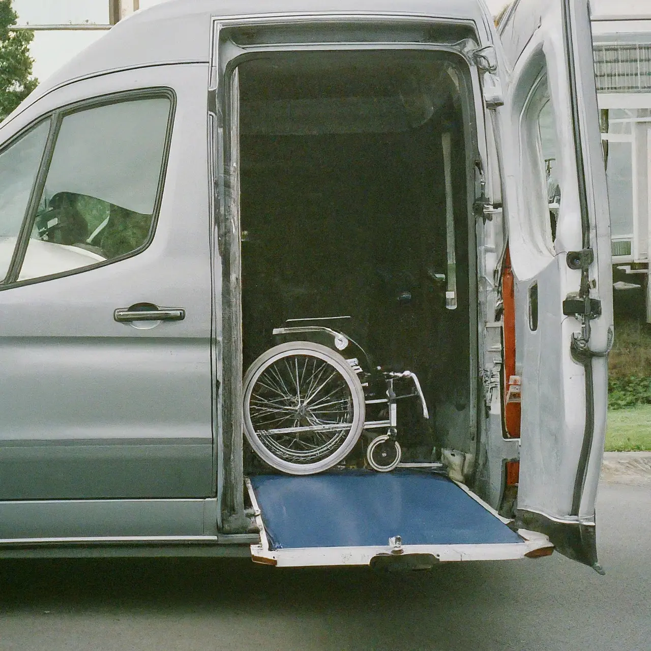 A modern, accessible van with a wheelchair lift in action. 35mm stock photo