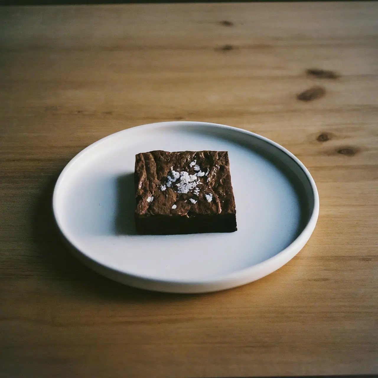 A plate of sea salt brownies on a wooden table. 35mm stock photo