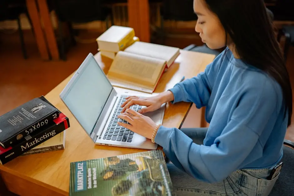 A Student Typing on Her Laptop