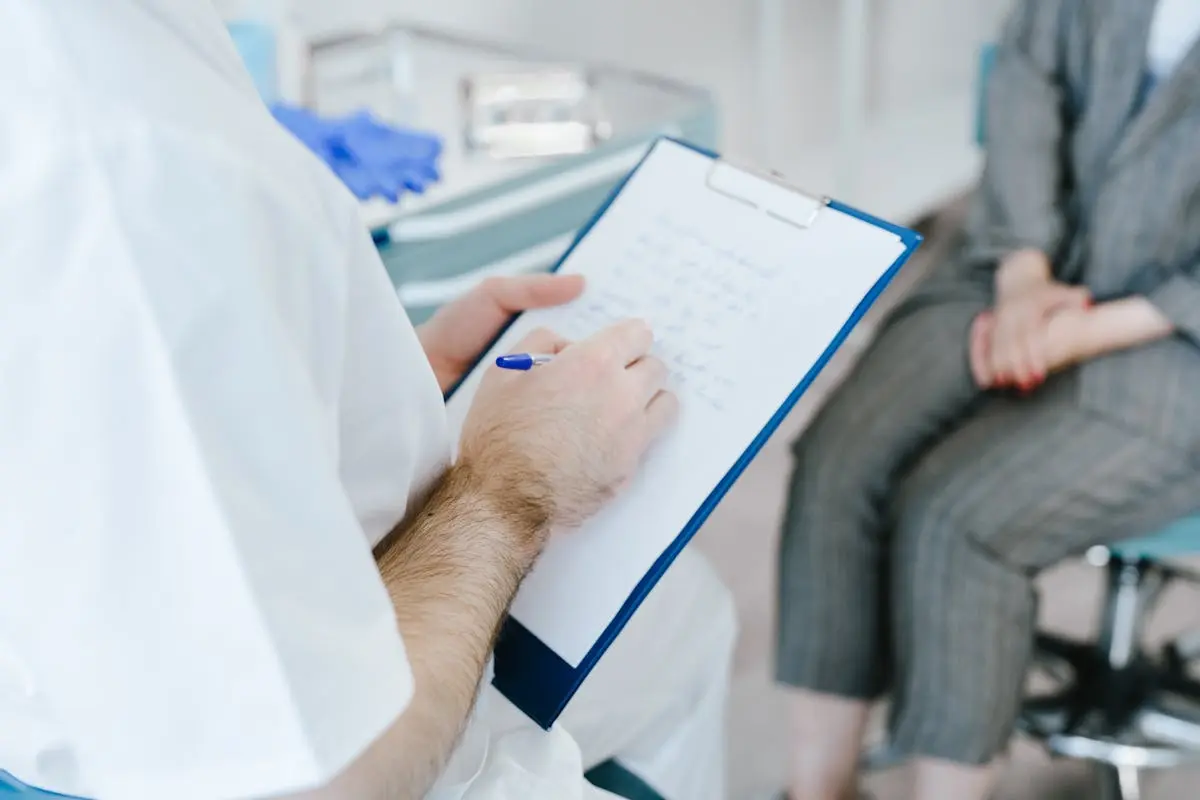 A Person Taking Notes While Talking to the Patient