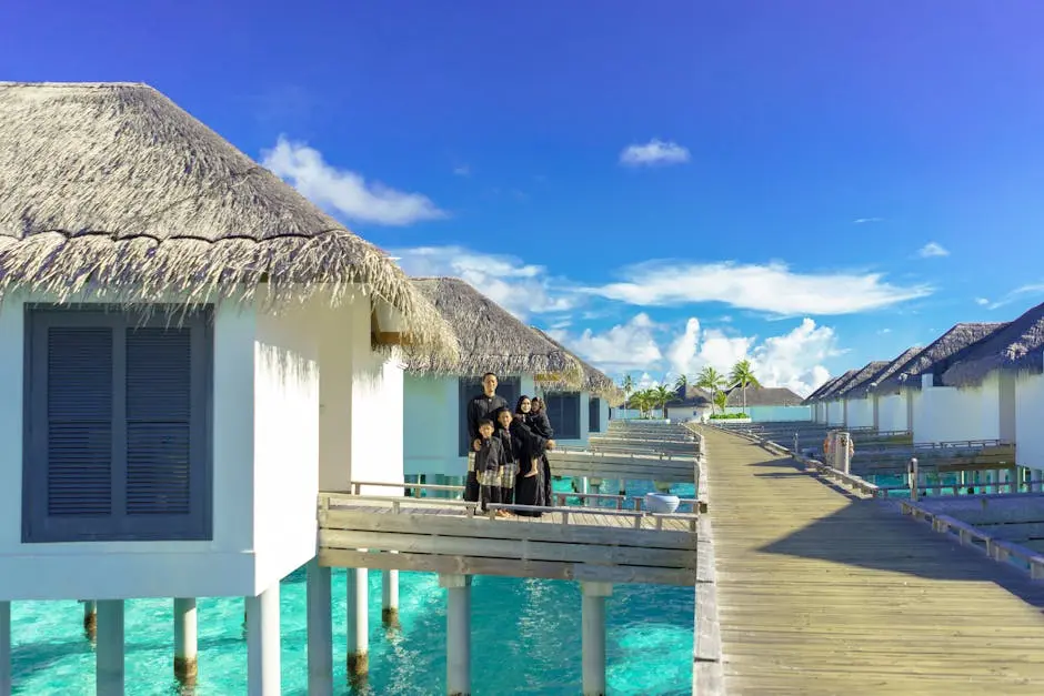 Family enjoys a sunny day on a resort’s boardwalk with overwater bungalows and clear blue sky.