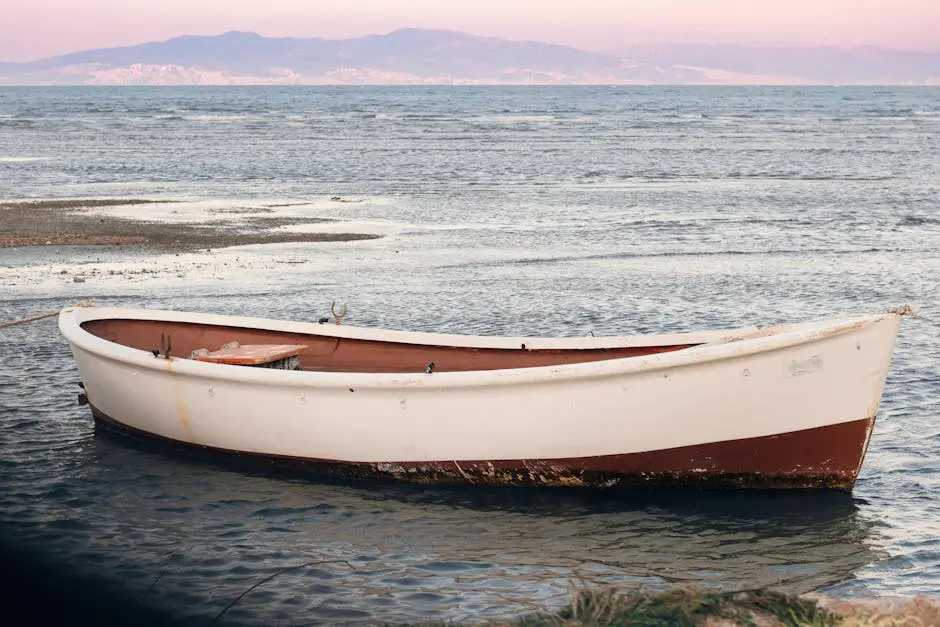 A peaceful scene of a lone boat floating on the water during sunset in Urla, İzmir, Türkiye.