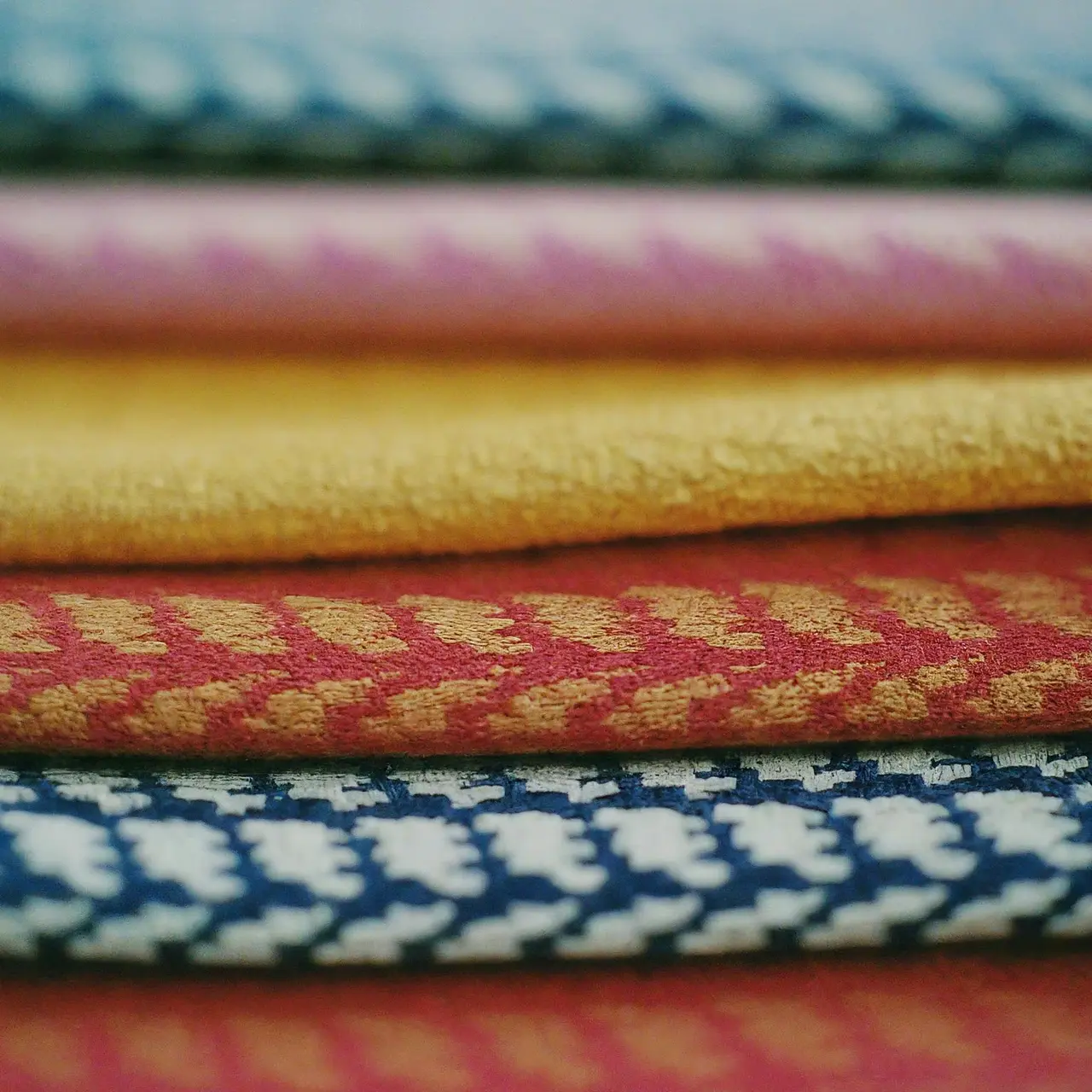 Close-up of colorful cotton jacquard fabrics stacked neatly. 35mm stock photo