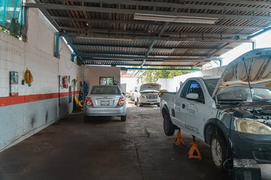 A busy automobile workshop interior showcasing cars undergoing repair and maintenance.