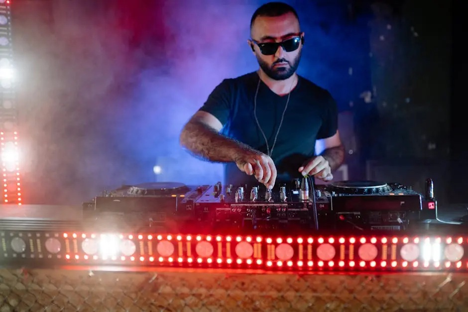 A Bearded Man Wearing Black Sunglasses Playing the Dj Mixer