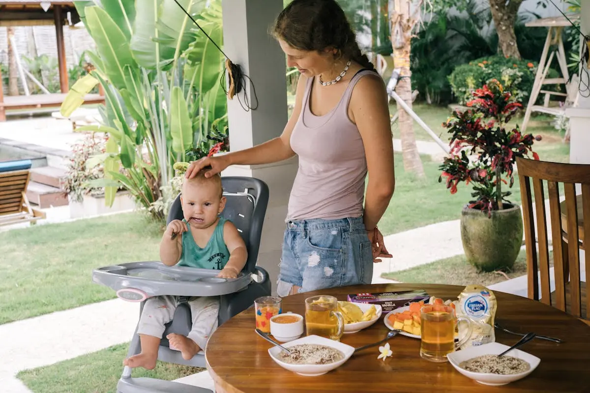 Mother Looking at Her Cute Baby Sitting on a High Chair