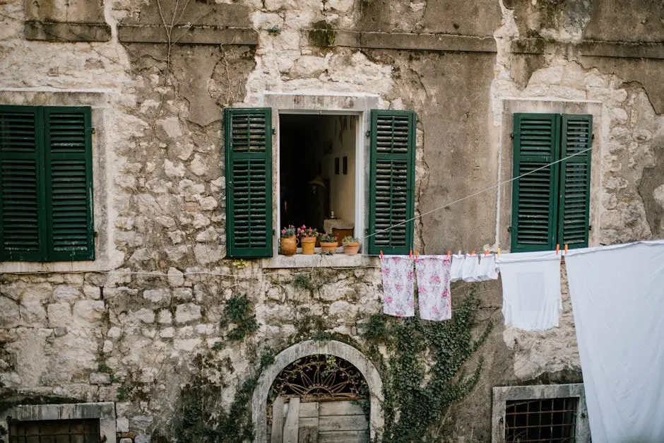 Old shabby brick building with windows with opened shutters