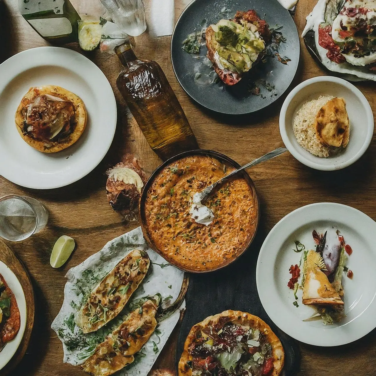 A top-down view of diverse gourmet dishes and tequila bottles. 35mm stock photo