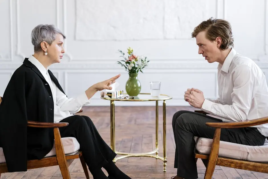 A therapist and a patient engage in a thoughtful counseling session indoors.