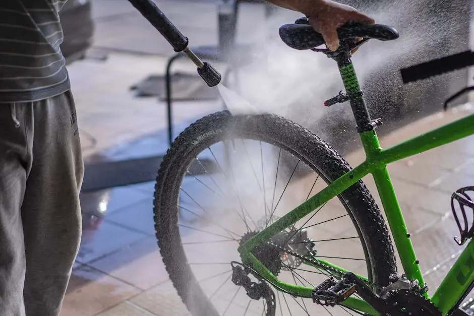 Man Washing a Bicycle with a Hose