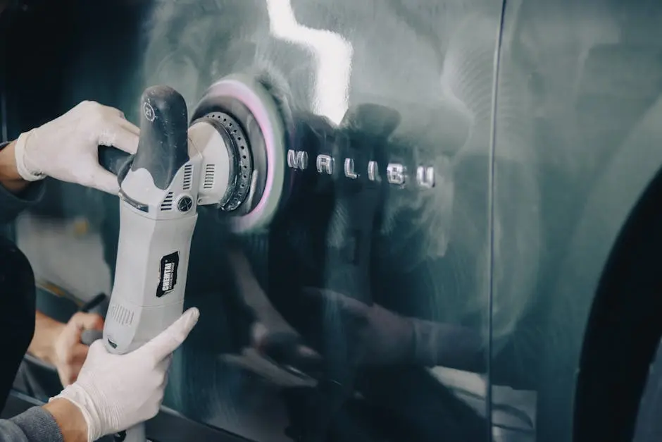 Close-up of hands polishing a car with a buffer, highlighting automotive detailing.