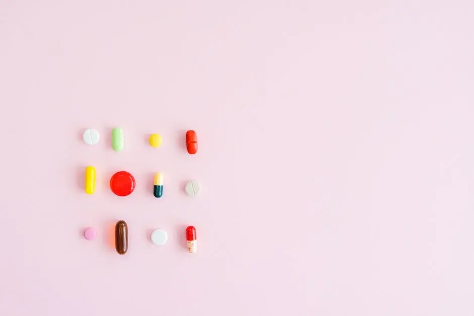 Colorful assortment of pills and capsules arranged on a pastel pink background, perfect for healthcare themes.