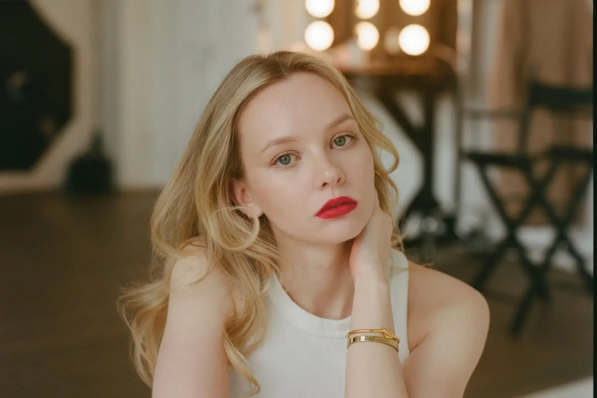 A woman with red lipstick sitting on a chair