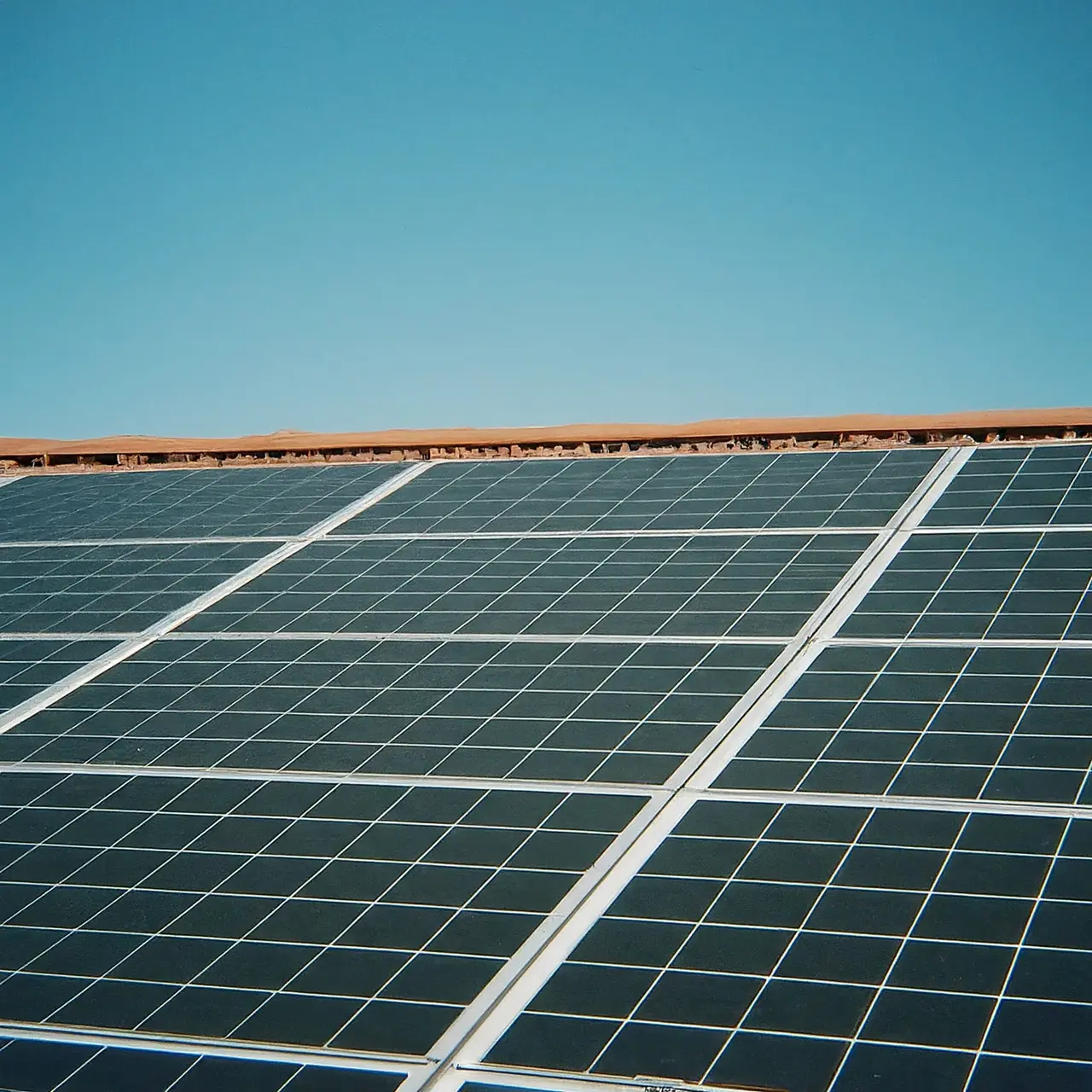 A rooftop with solar panels under a bright blue sky. 35mm stock photo