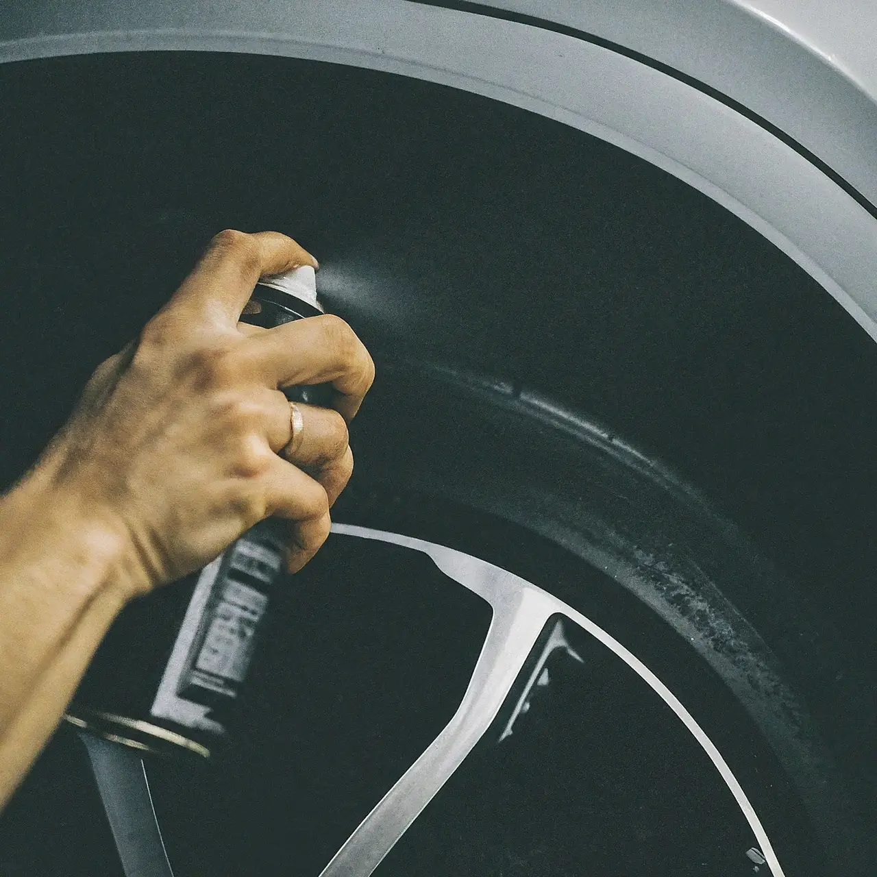 Close-up of tire shine spray being applied on a car tire. 35mm stock photo