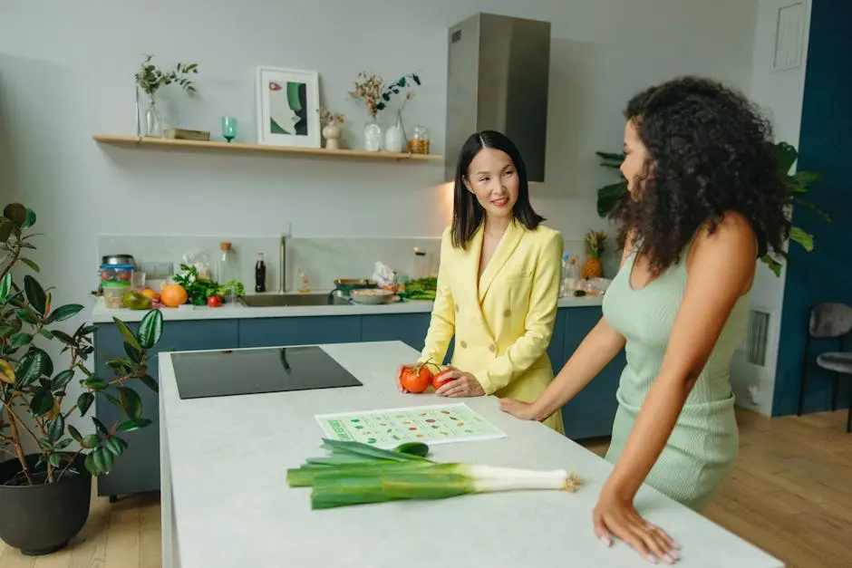 Two women discussing a healthy diet in a modern kitchen with fresh vegetables.