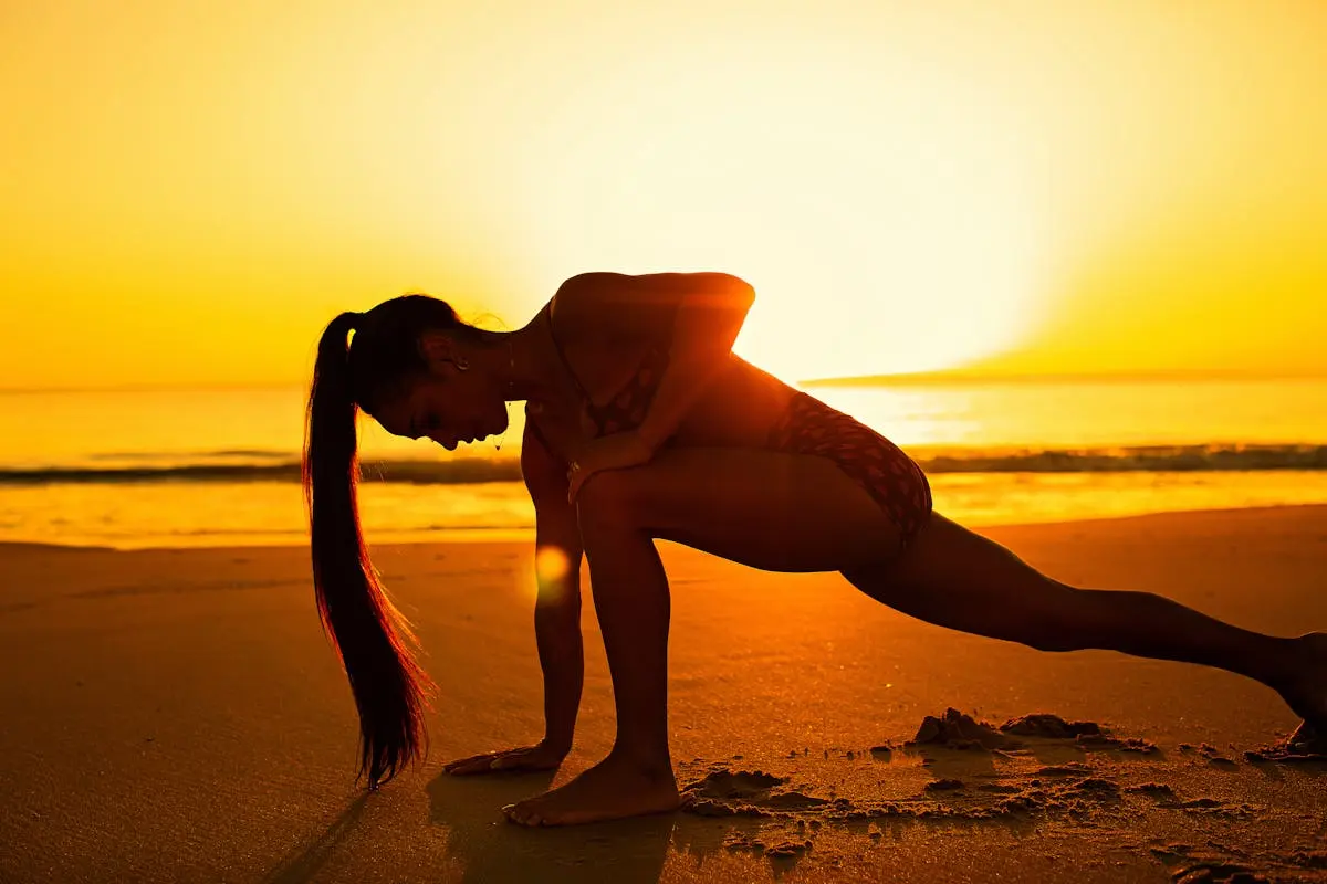Woman Stretching on the Beach at Sunset 