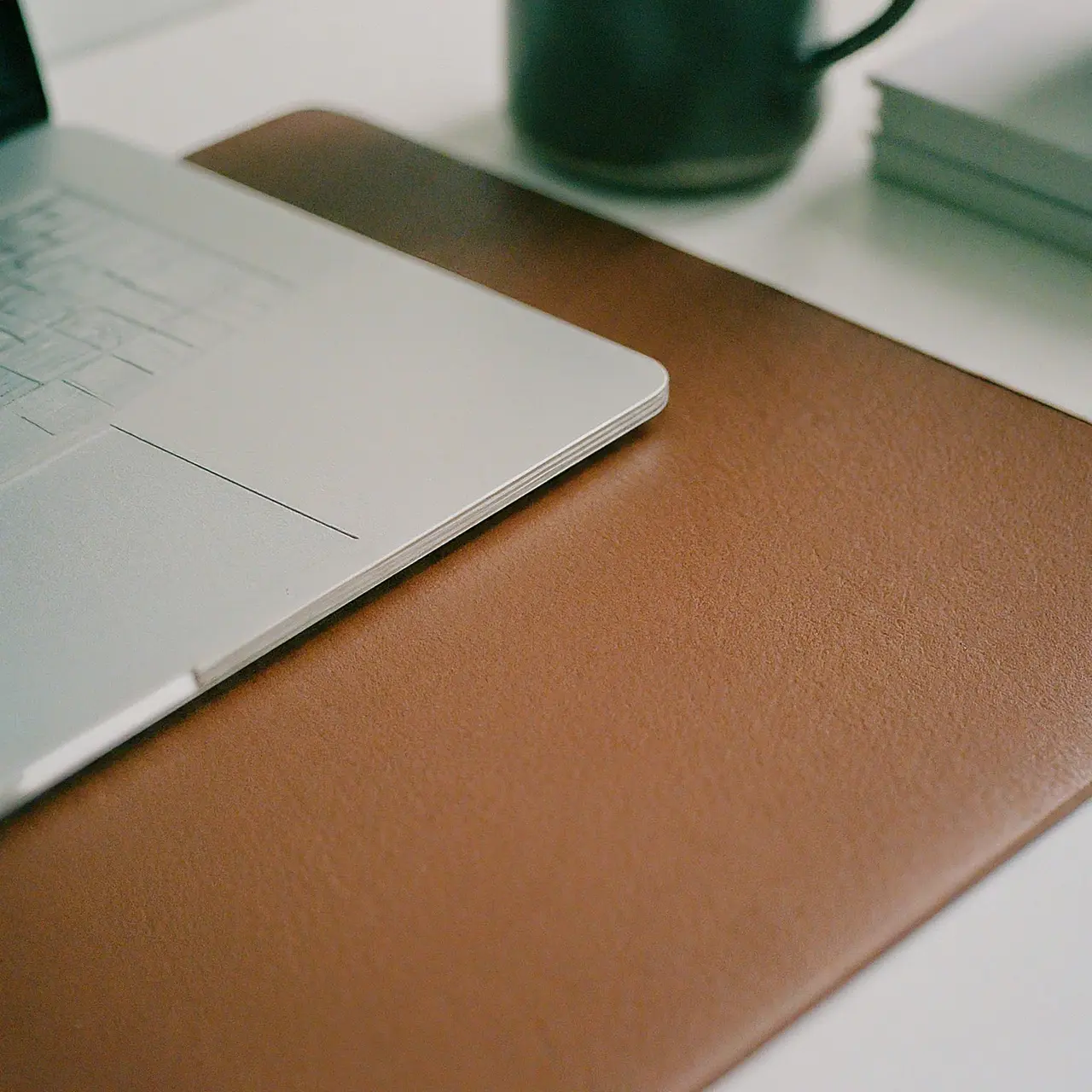 A sleek leather desk mat on a modern office desk. 35mm stock photo