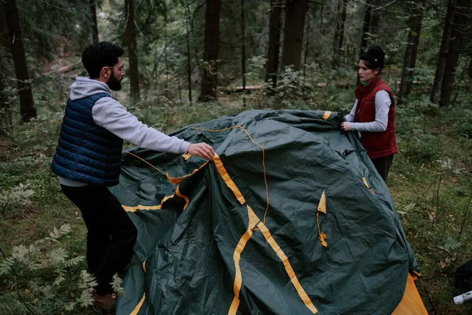 A couple assembles a green tent in a lush forest, enjoying outdoor camping.