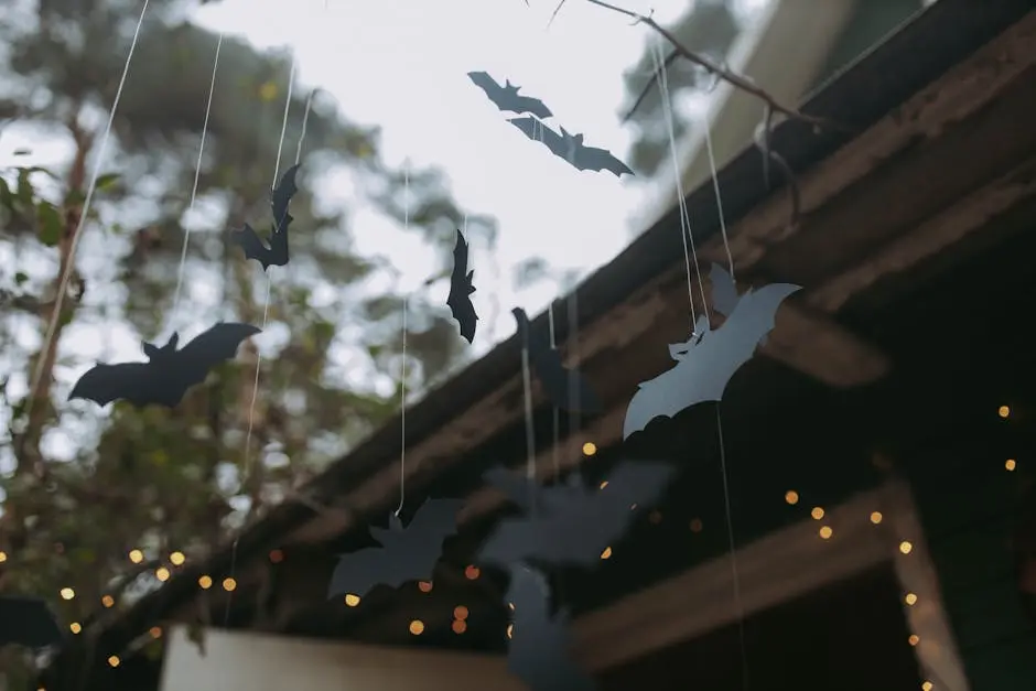 Outdoor Halloween cutout bat decorations hanging with lights. Perfect spooky decor for fall evenings.