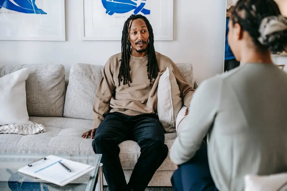 Therapist and patient engaged in a thoughtful psychotherapy session indoors.