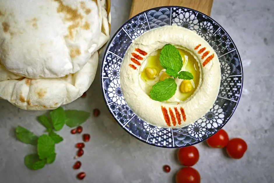 A bowl of hummus with pita bread and mint