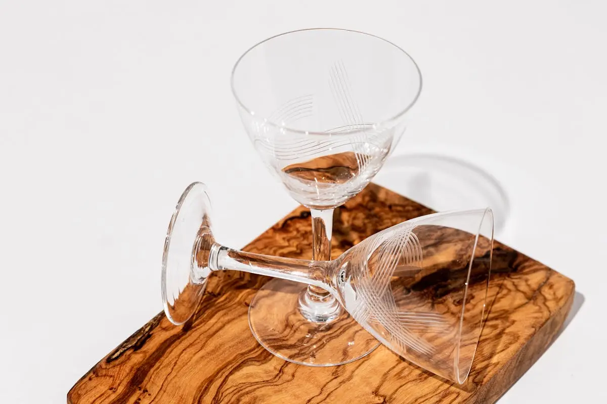 Thin tall beverage glasses on a wooden cutboard