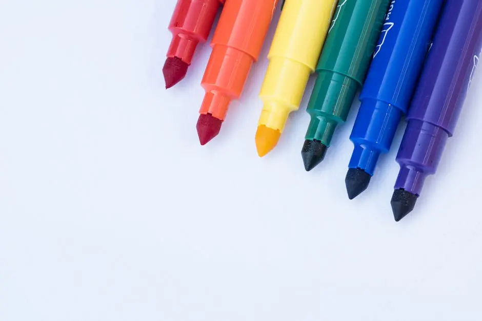 Vibrant rainbow-colored markers placed on a blank canvas, ready for creativity.