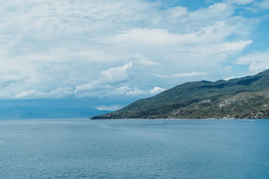 A scenic ocean view of an island surrounded by blue waters under a cloudy sky.