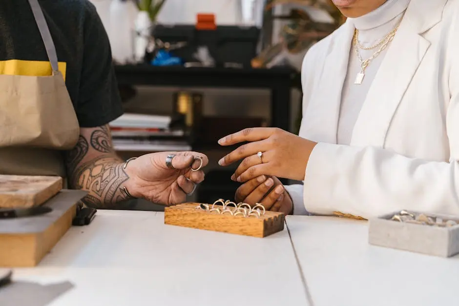 Close-up of hands exchanging rings in a jewelry workshop, showcasing handmade design.