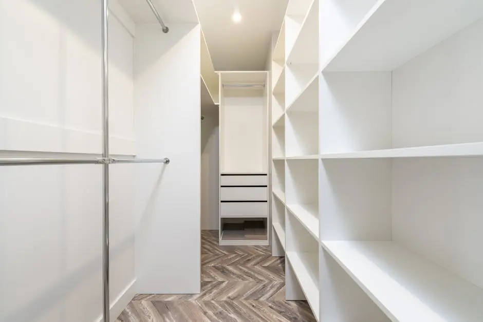 Elegant modern walk-in closet with white shelves and storage, offering a clean and organized interior design.