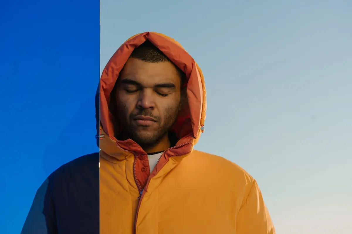 Man in Orange Puffer Jacket Under Blue Sky