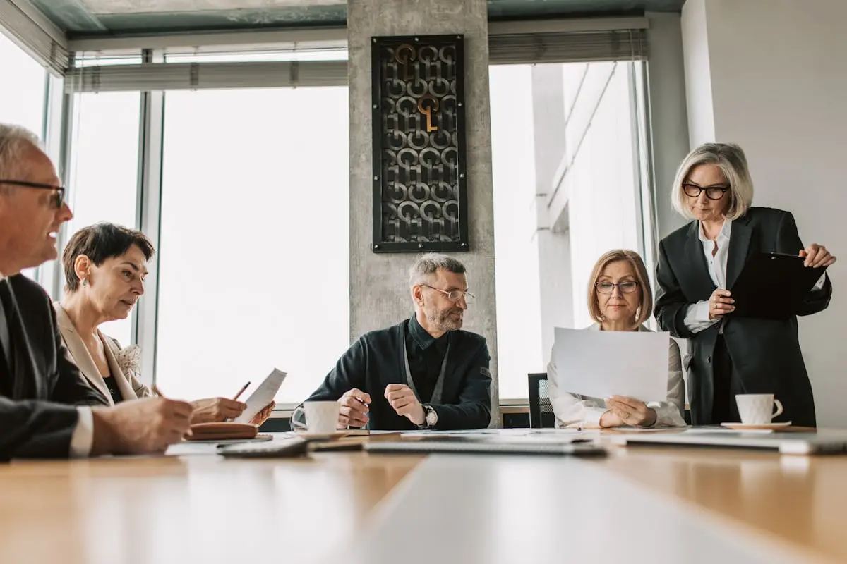 Business professionals discussing documents in a modern meeting room.