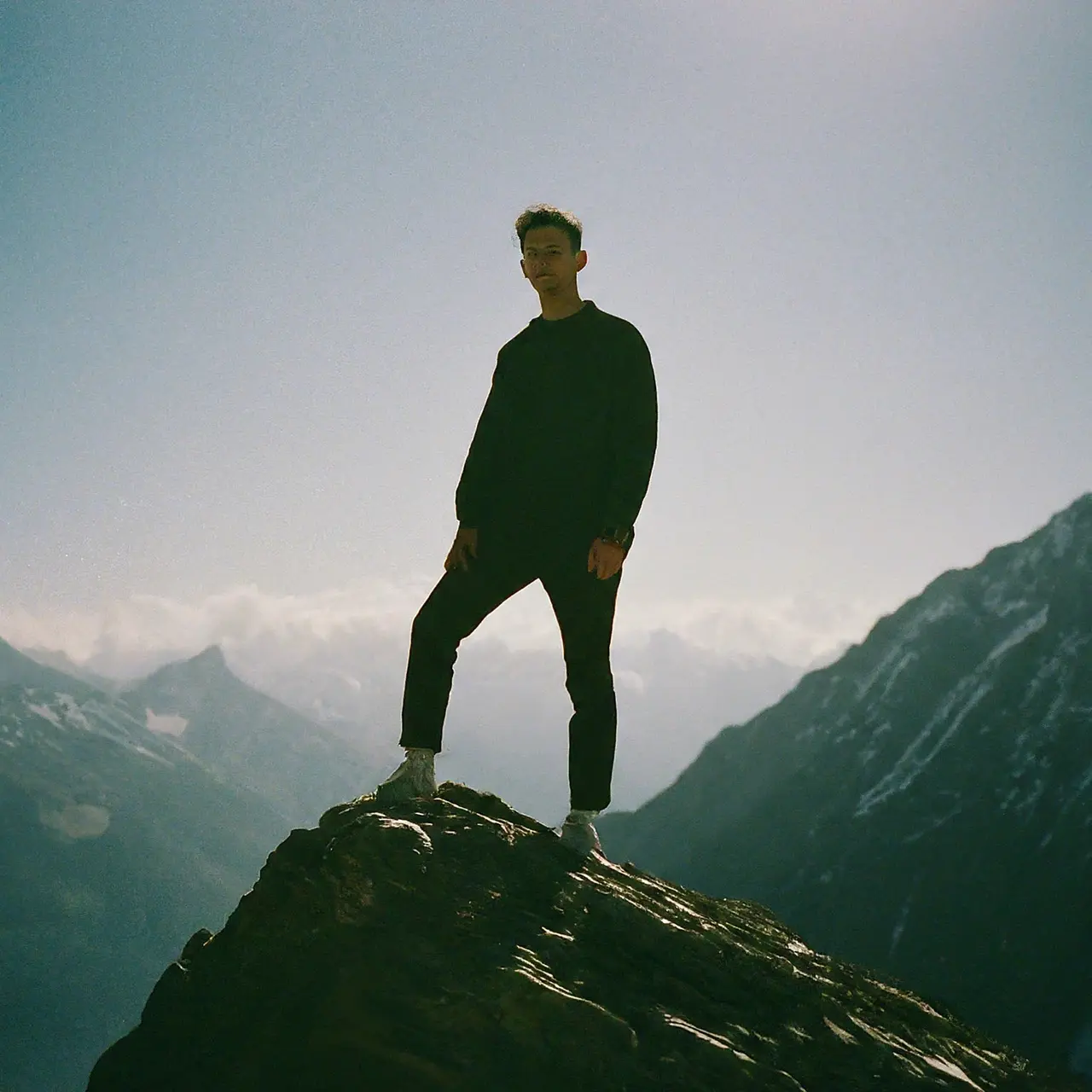 A confident silhouette standing tall on a mountain peak. 35mm stock photo