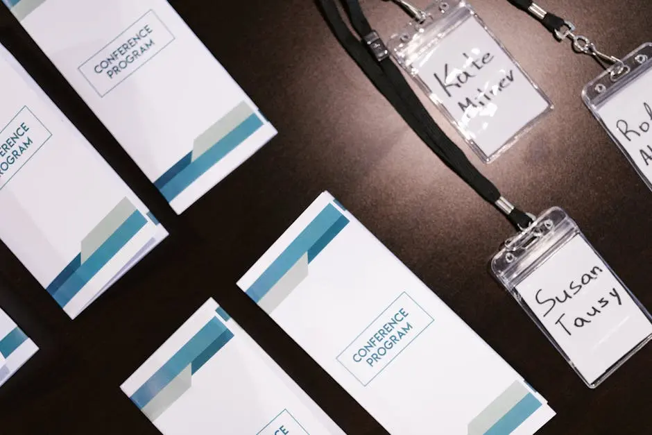 High-angle view of conference programs and name badges on a table, ideal for corporate event visuals.