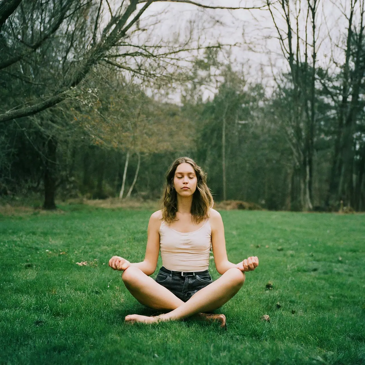 A serene person meditating in a tranquil outdoor setting. 35mm stock photo