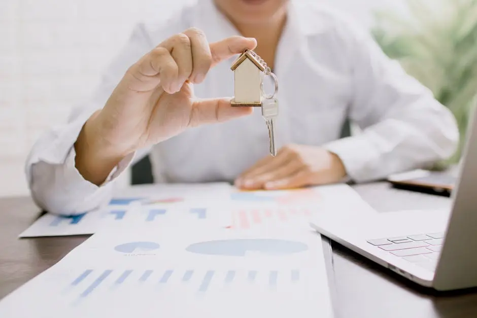 Real estate professional presenting a house model with keys, symbolizing property investment and ownership.