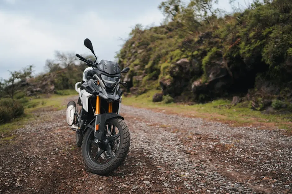 A motorcycle parked on a dirt road near a mountain