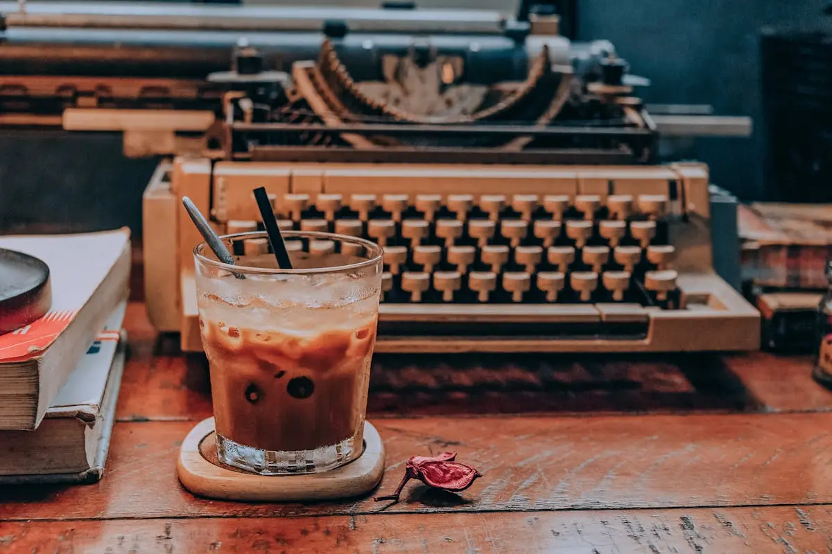 Cold Coffee in Glass Near Typewriter