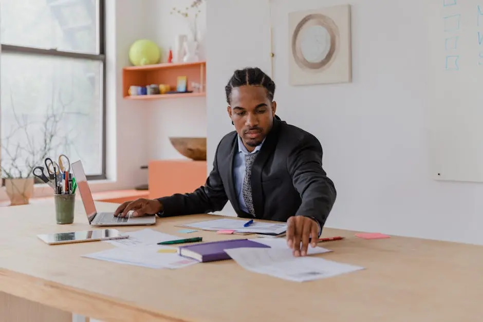 Businessman Working with Documents and Using Laptop in an Office