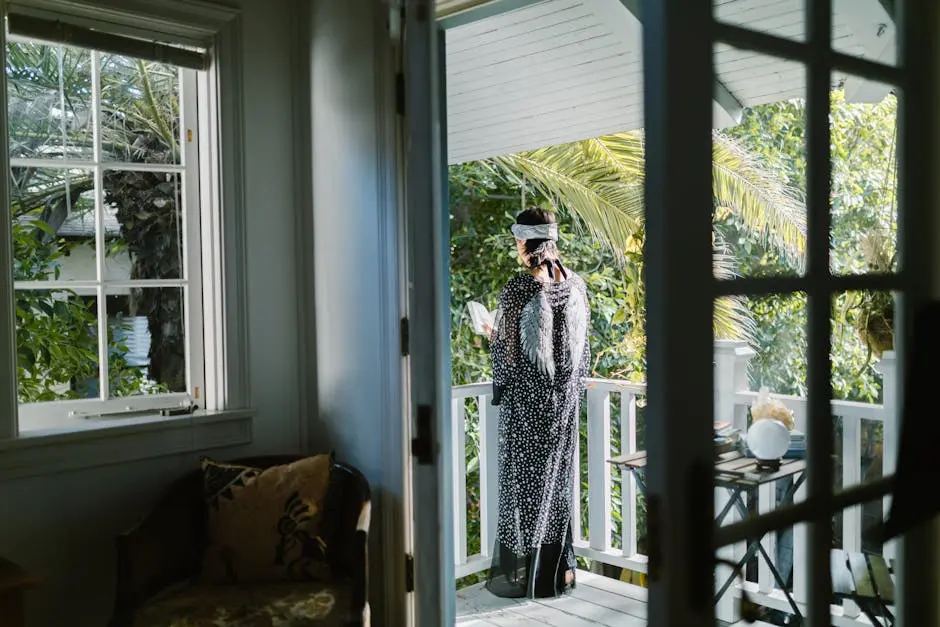 Woman in Black and White Long Sleeve Dress Standing Near Glass Window