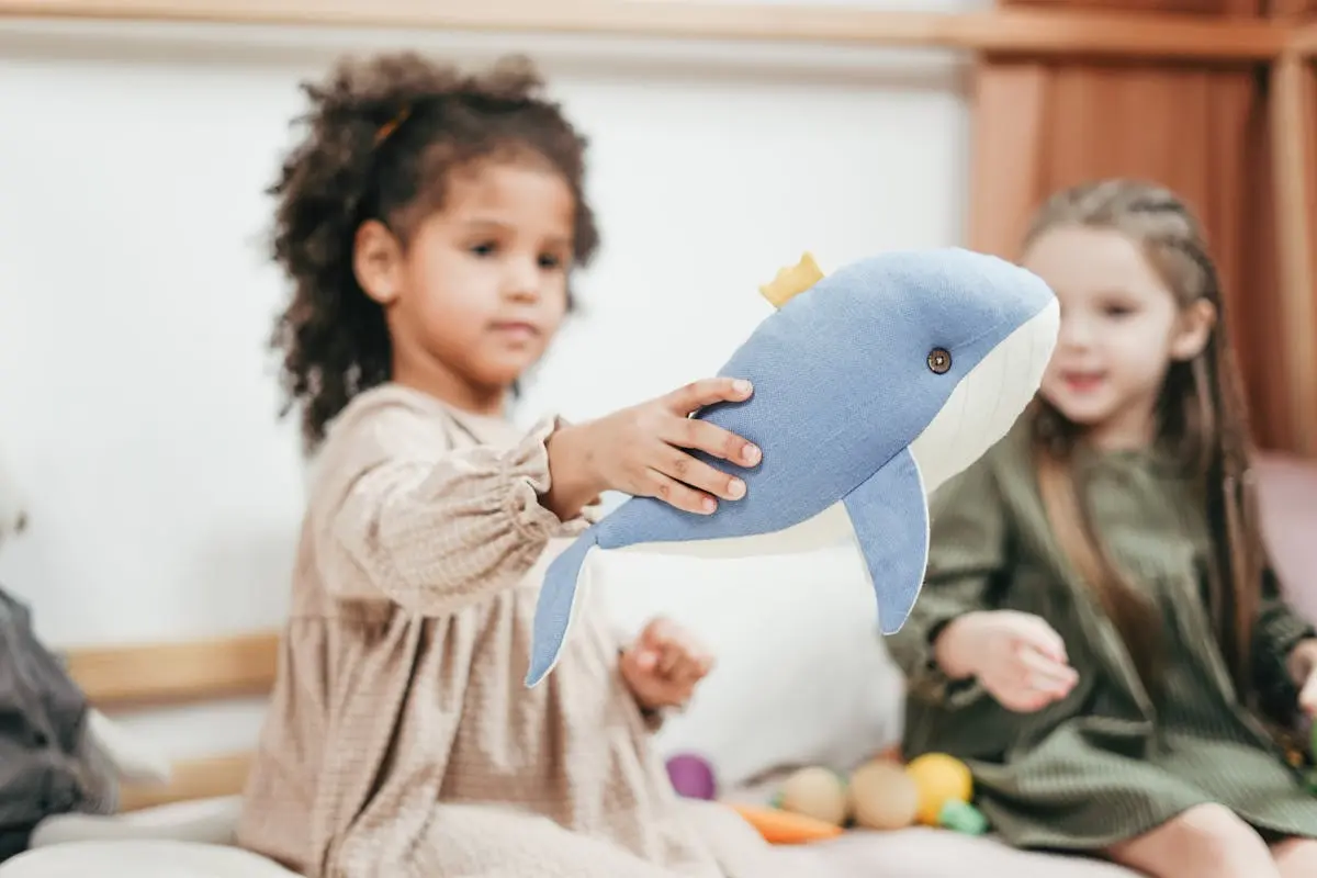 Shallow Focus Photo of Girl Holding Stuffed Toy