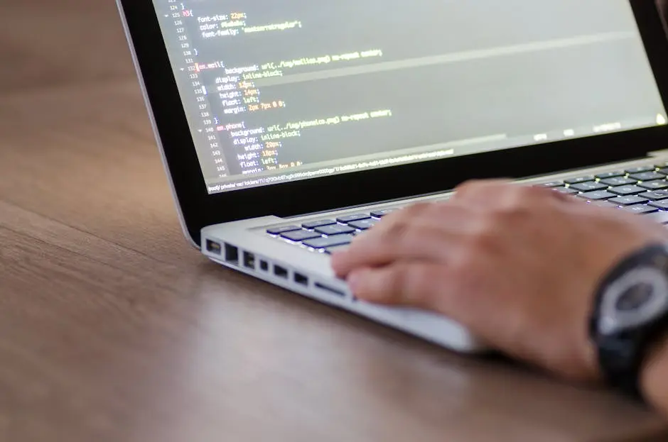 Person coding on a laptop with HTML code on screen, showcasing development work.