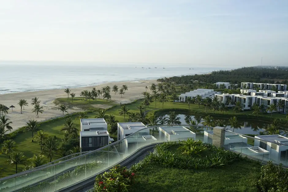 Scenic view of modern beachfront villas and lush greenery overlooking the ocean.