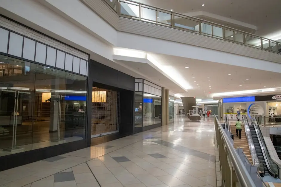 A large shopping mall with escalators and glass doors