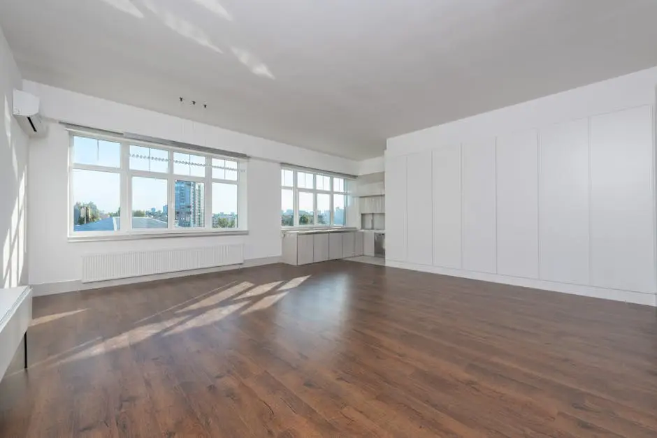 Bright and modern empty room with wooden floors and large windows, perfect for home design inspiration.