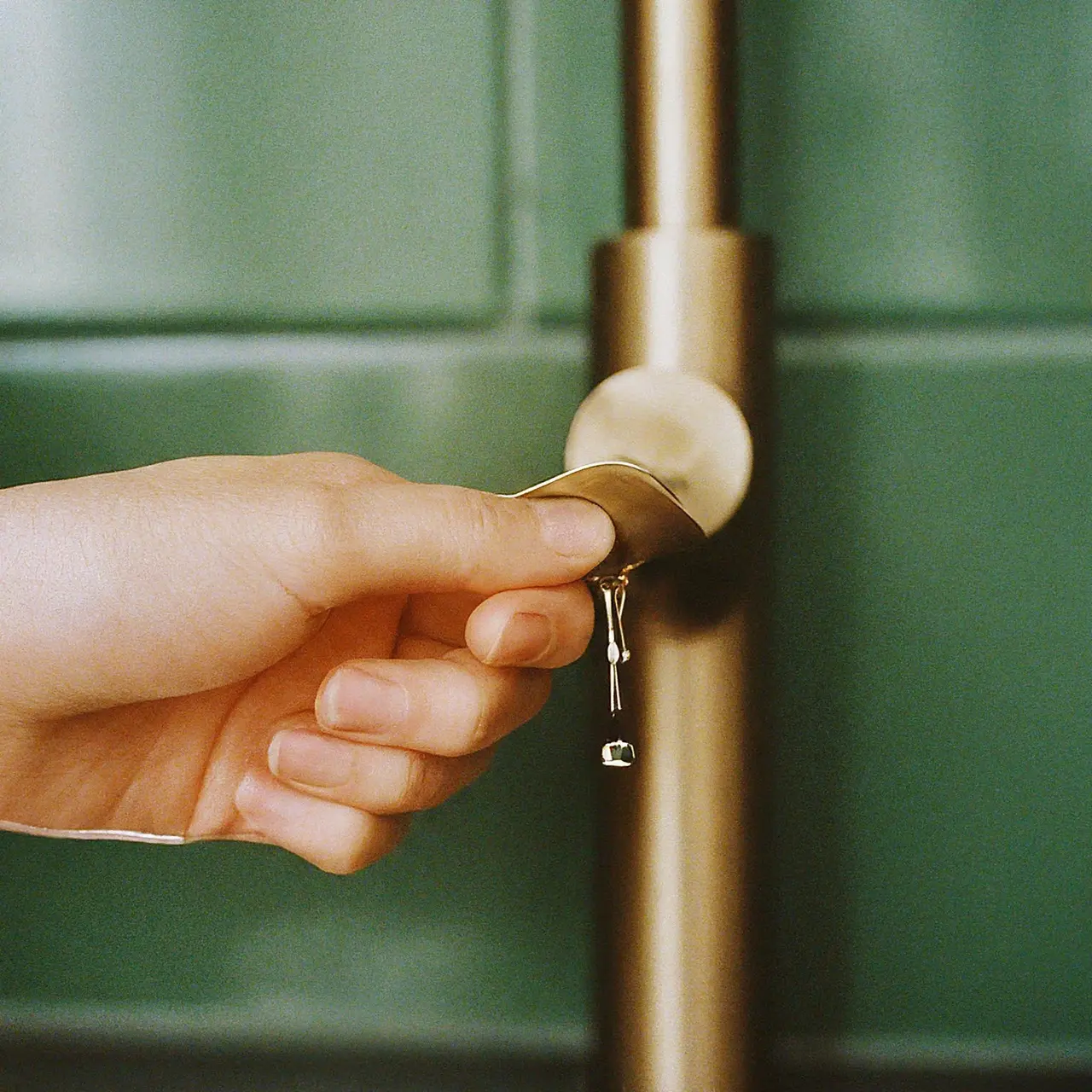 A hand turning off a dripping faucet. 35mm stock photo