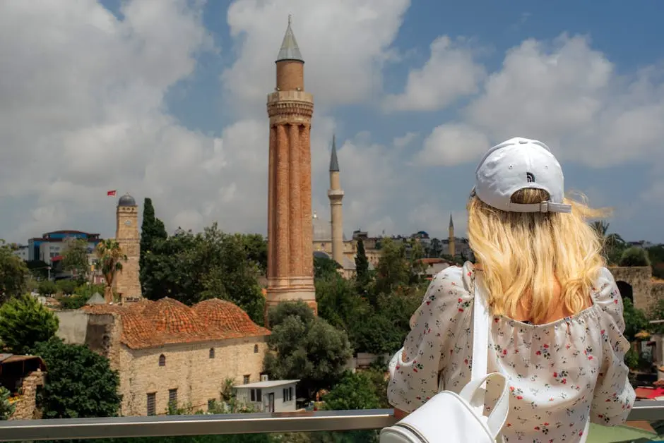 A woman looking out over the city with a tower in the background