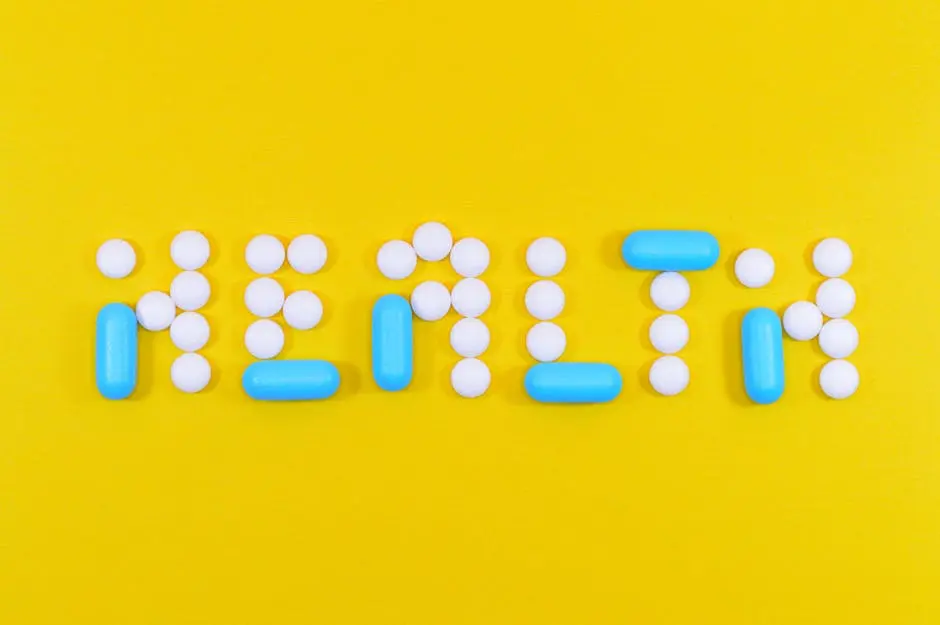 Pills spelling ‘health’ on a vibrant yellow background, symbolizing wellness.