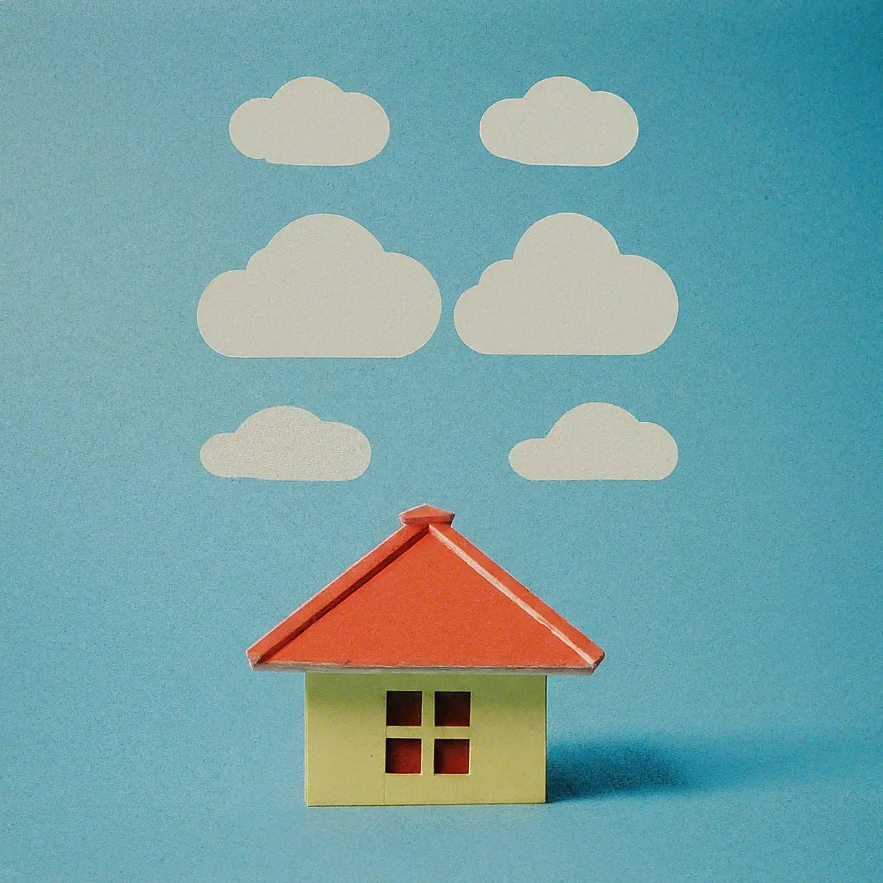 Cloud icons above a model house on a blue background. 35mm stock photo